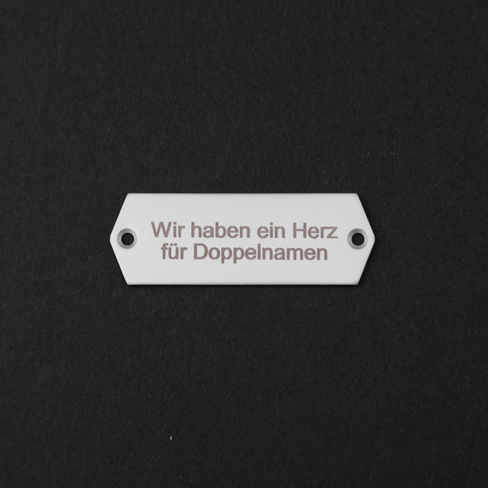 Edelstahl-Gravierschild liegend; darauf steht "Wir haben ein Herz für Doppelnamen"