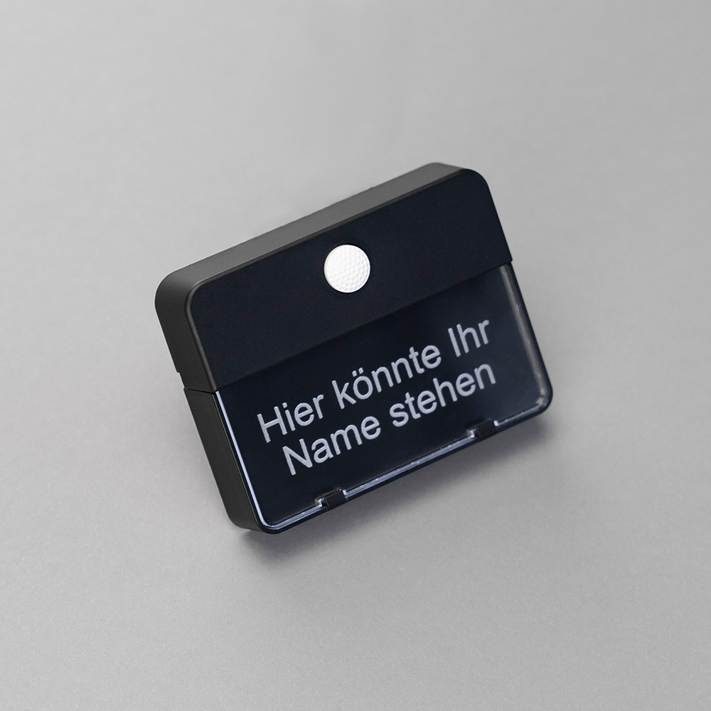 Schwarzer ETA 651-Klingeltaster auf grauem Hintergrund; auf dem Namensschild steht "Hier könnte Ihr Name stehen"